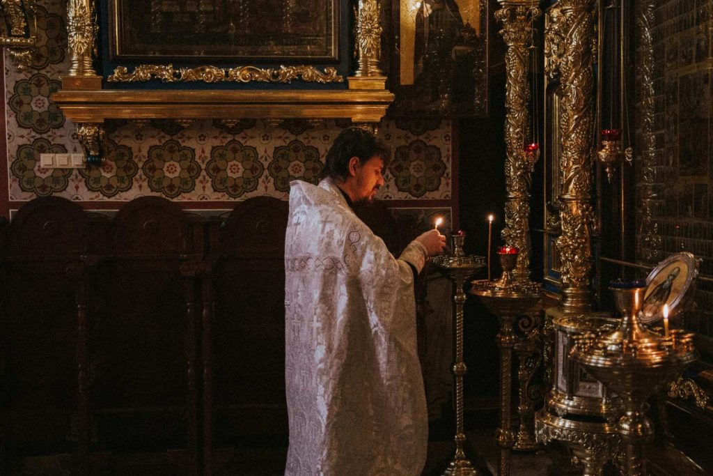 man wearing white robe holding candle
