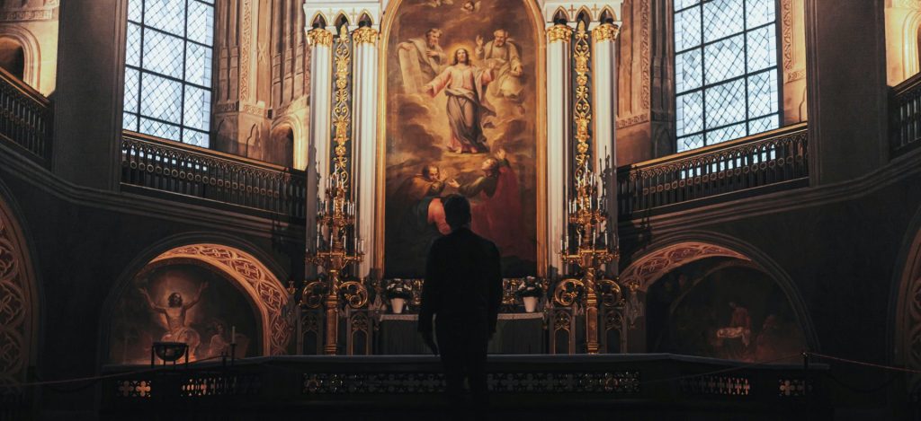 a man standing in front of a painting in a church